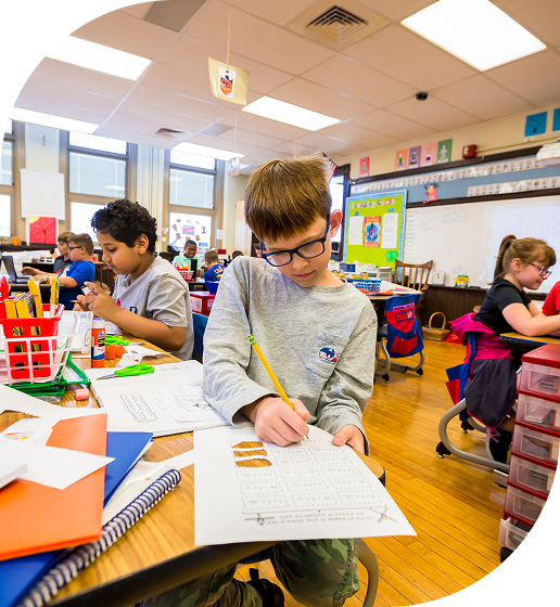 A classroom filled with engaged students working on their assignments at their desks.